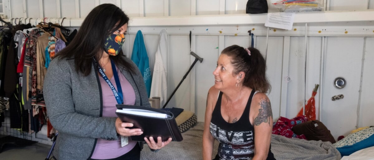 Maria Hodson, A Housing Specialist With The Santa Ana Housing Authority, Talks With Sandra Brooks At Her Bed At The Link Homeless Shelter In Santa Ana, CA On Friday, August 28, 2020. Four Non-profits In Orange County Have Partnered To Help People Like Brooks Get Permanent Housing. Brooks Received A Section 8 Voucher In May.