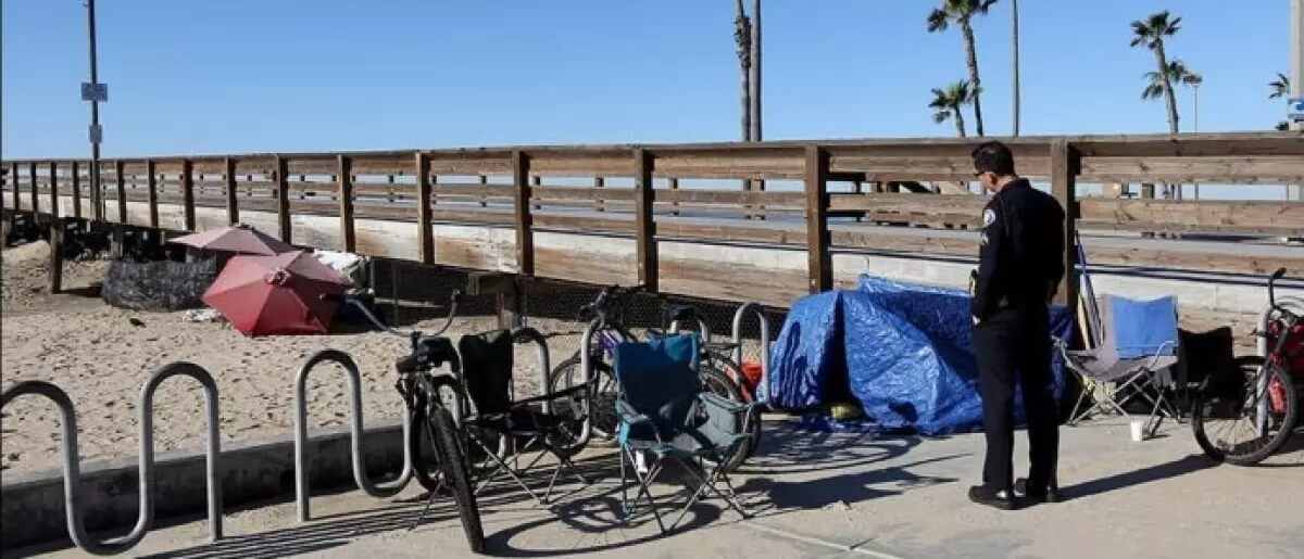 Tony Yim, A Homeless Liaison Officer With The Newport Beach Police Department, Speaks With Homeless People Staying At The Balboa Pier In 2019.