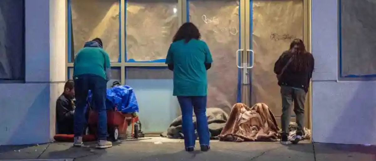 Volunteers Jorge Solorzano, left, a Health Coach at CalOptima; Yolie Negrete, center, a program supervisor at City Net, and Katherine Ibarra, right, of the Garden Grove Regional Center, speak with homeless individuals in the entrance to a building on W. Civic Center Drive in downtown Santa Ana early Tuesday morning, Jan. 23, 2024. Volunteers for the Everyone Counts, Point In Time, a homeless survey, spread out throughout central Orange County on Tuesday, the first day of the survey, to gather data that will help address homeless issues. (Photo by Mark Rightmire, Orange County Register/SCNG)